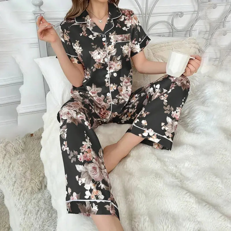 Ensemble en satin fleuri pour femme posé sur un lit clair