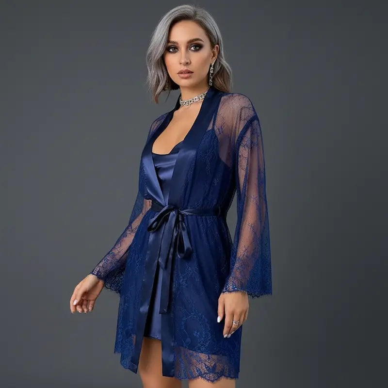 Nuisette satin bleu nuit avec peignoir transparent en dentelle florale porté par un mannequin sur fond gris studio.