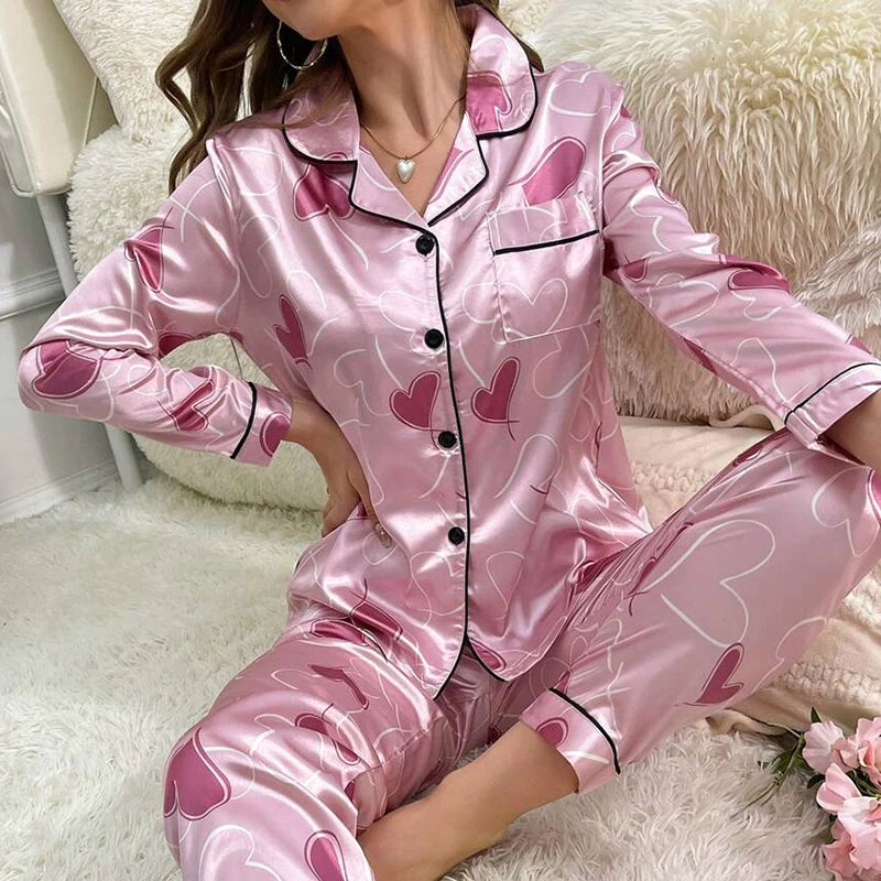 Pyjama satin rose pour femme avec motifs cœurs, ensemble deux pièces à boutons et finitions contrastées pour une tenue douce et romantique.