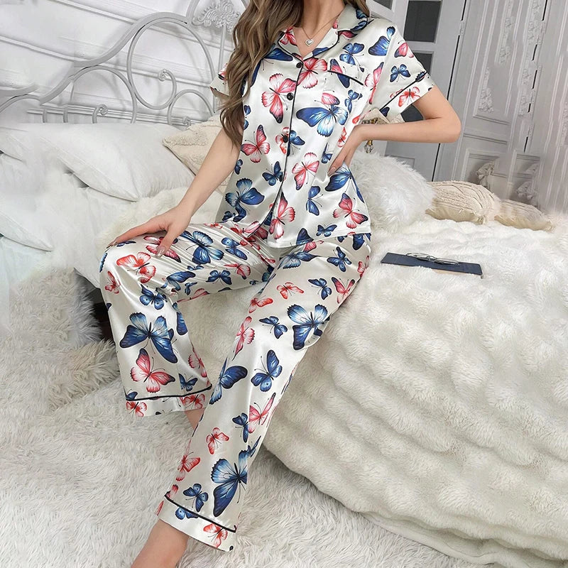 Pyjama en satin papillons pour femme posé sur un lit clair